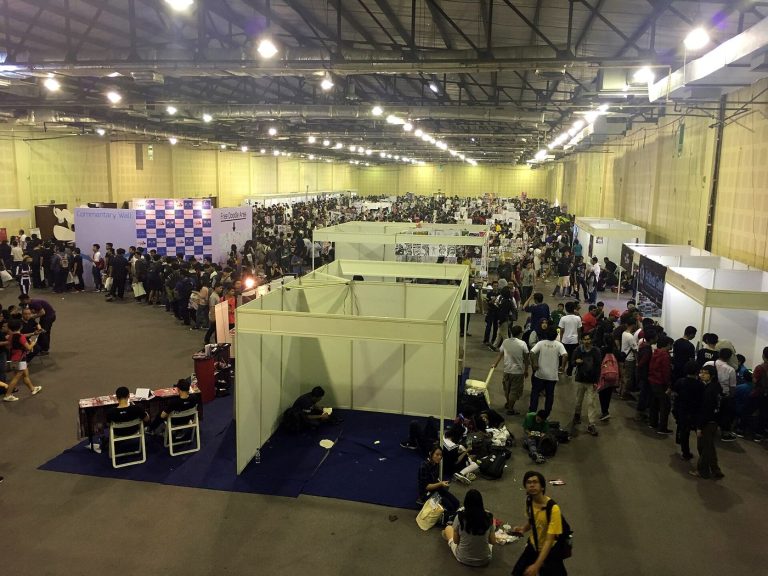 Crowds browsing manga and fan-made comics at a large Japanese comic convention